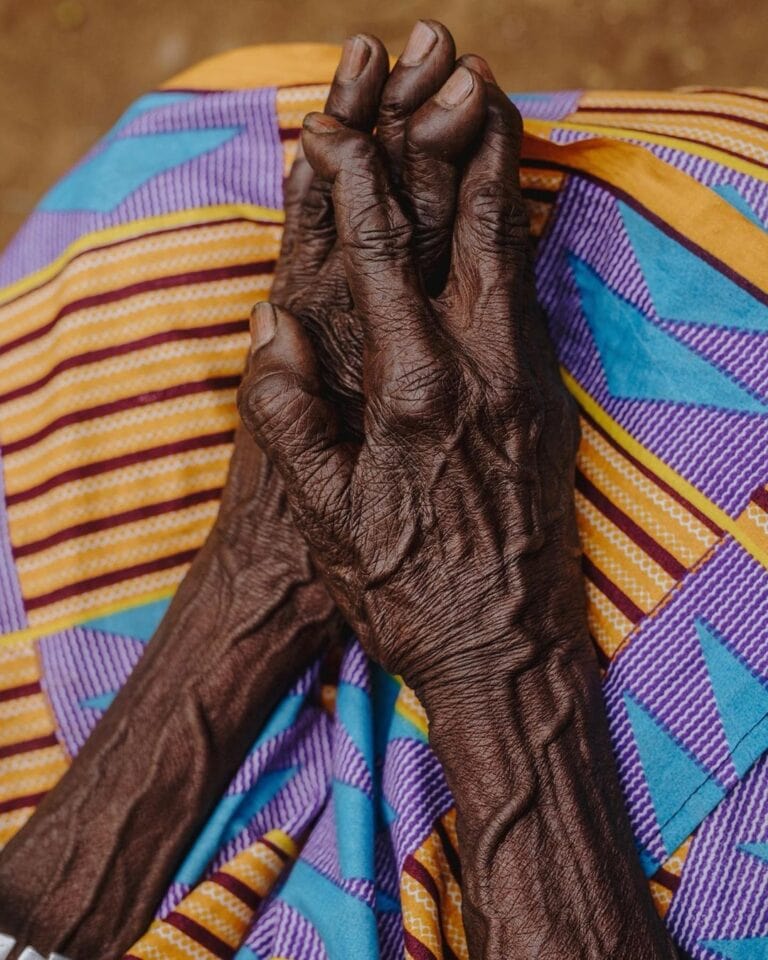 an image of an older persons's hands in their lap folded nicely_living in kigali