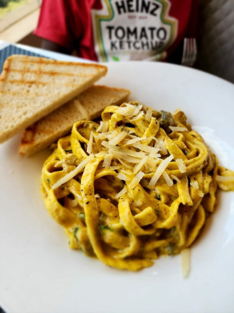 creamy pasta with mushrooms and two pieces of bread. The Hut Kigali Rwanda